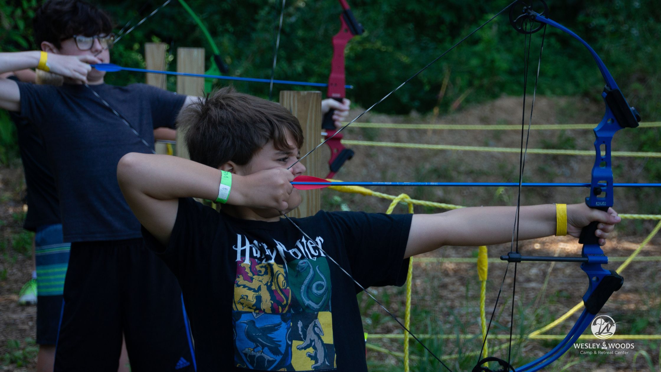 Young camper shoots an arrow on the archery range