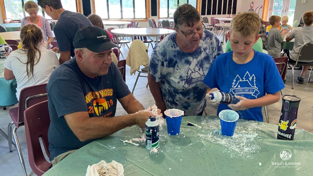 Grandfather, grandmother and grandson working on a shaving cream craft.