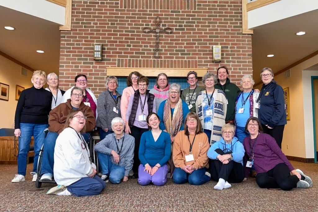 20 women pose in front of the fireplace in Littleton Lodge