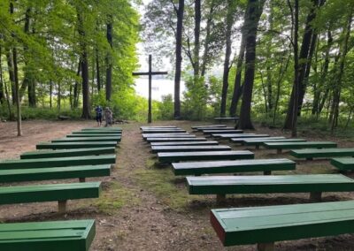 freshl painted benches overlooking the woods, lake and cross